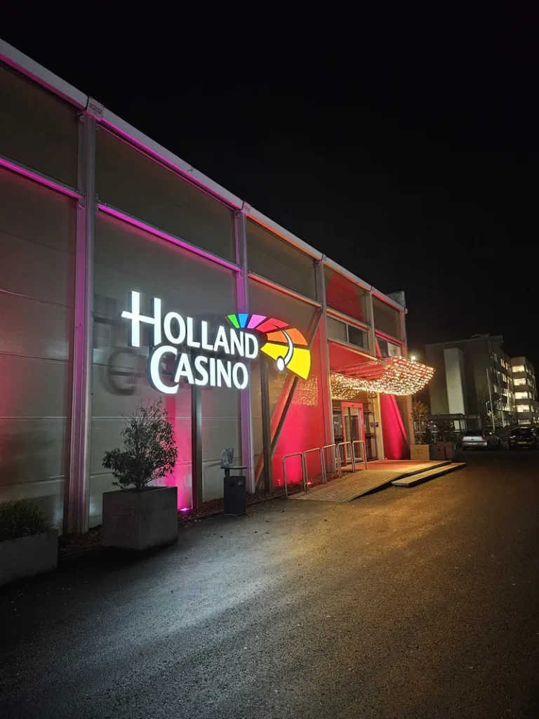 Verlichte ingang van Holland Casino Groningen bij avond