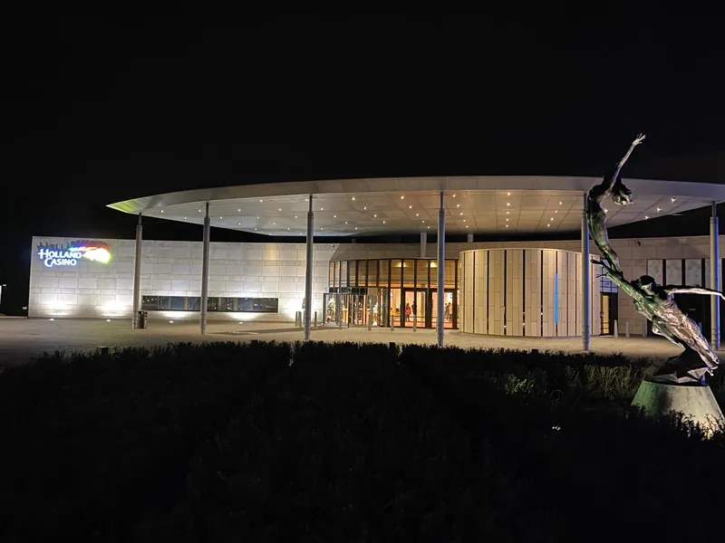 Verlichte ingang van Holland Casino Valkenburg bij nacht